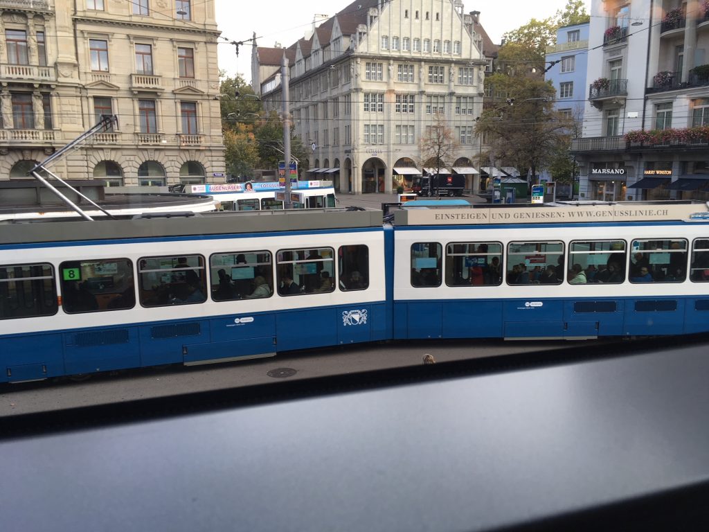 Blick aus dem Fenster des Café Lindt & Sprüngli in Zürich. Es fährt eine Strassenbahn und dahinter sind Häuser zu sehen